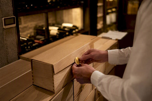 Hands sealing boxes of unopened event wine